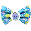 Sumer themed, pet bow tie. Turquoise, with seaside shells printed. Pink and yellow. Badge in the middle that says " Shell Yeah"