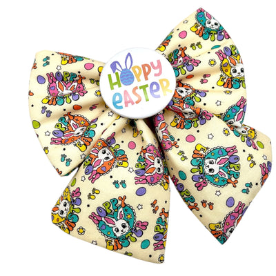 Easter sailor bow for dogs. Cream bow with Hoppy Easter written across the bow, with a bunny. Colourful and fun lettering. Colourful badge in the middle that reads " HOPPY EASTER"