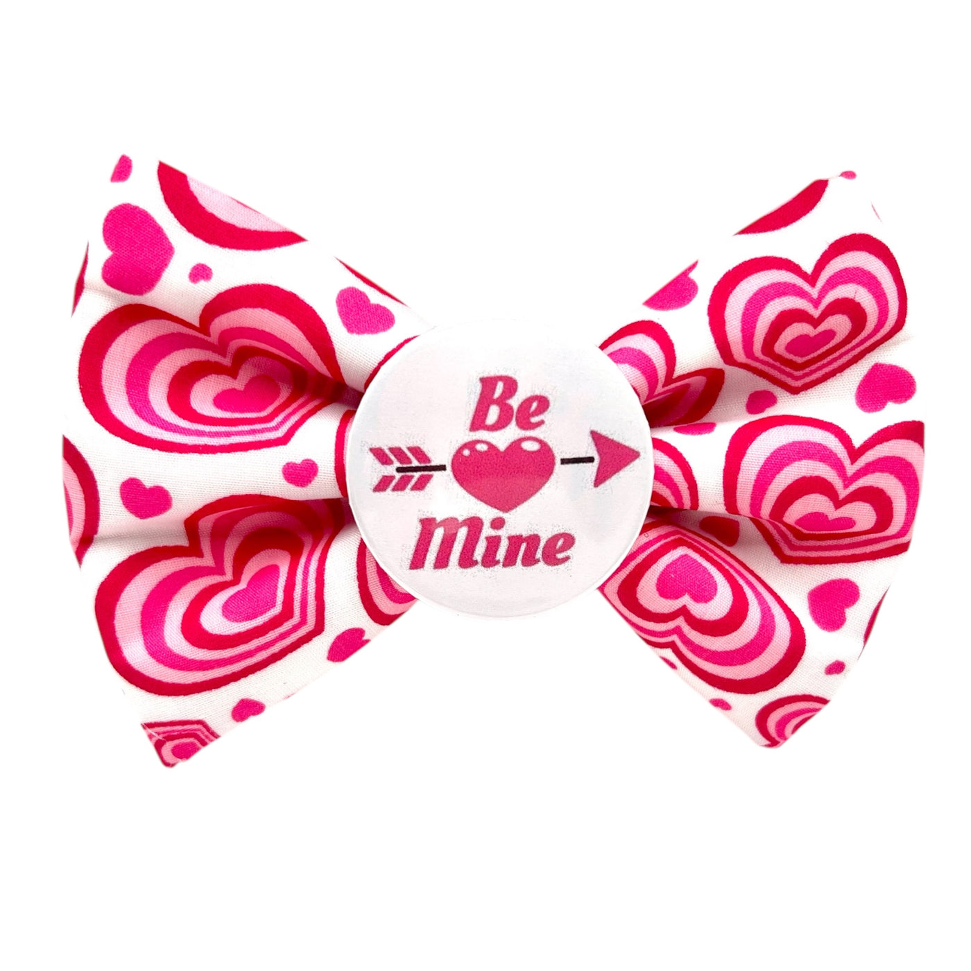 Valentine's dog bow tie. White bow with pink hearts. Badge in the middle with text " BE MINE" with a pink heart and arrow. 