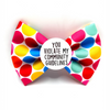 Colourful polka dot, dog bow tie with a warning label on a white background
