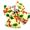 A woodland dog bow featuring a playful pattern of orange foxes, green trees, and brown branches on a pale yellow background, with a round white button in the centre that reads 'FOR FOX SAKE' with a small fox illustration.