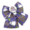 A purple Halloween themed sailor bow for dogs with a white plastic centre badge. The bow features a repeating pattern of white cartoon ghosts, green zombies, tombstones with 'RIP ALL MY FUCK' text, and orange and green 'SPOOKY LITTLE FUCKER' lettering.