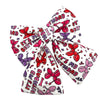 Birthday-themed dog bow tie with red, pink, and purple designs on a white background