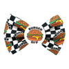 Checkered dog bow tie with burger design on a white background. Badge in the middle with an image of a burger, with text " Burger off"
