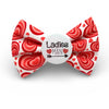 Red and white heart-patterned dog bow tie with a 'Ladies Man' label on a white background