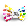 White dog bow tie with rainbow hearts. Rude badge in the middle. 
