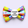 Colourful pet bow tie with heart patterns and a white Badge with 'Everybody Love Everybody' text on a light purple background.